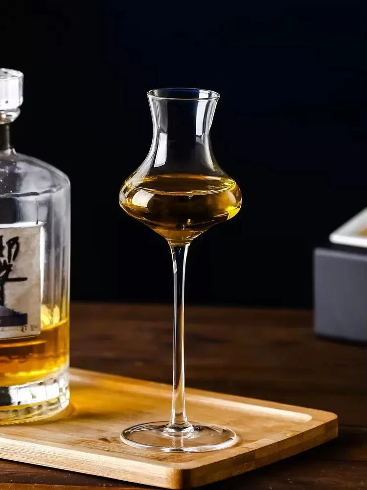 "Slender" crystal spirits glass filled with wine alongside a bottle, placed on a table, sleek elongated silhouette — CL House Drinkware collection