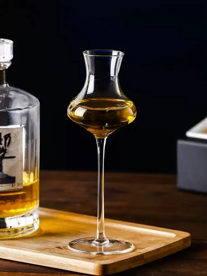 "Slender" crystal spirits glass filled with wine alongside a bottle, placed on a table, sleek elongated silhouette — CL House Drinkware collection