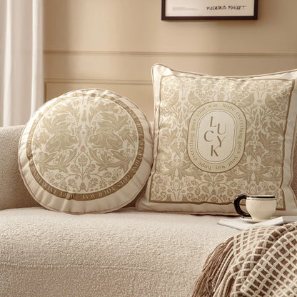  "Dark Forest" round and "Lucky Bloom" square botanical velvet cushion covers styled together on a cream boucle sofa, golden floral damask and botanical motifs in warm neutral tones — CL House Cushions collection