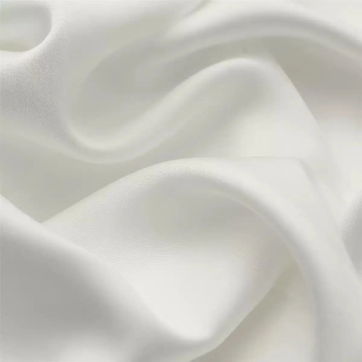 Close-up of the smooth, silky-soft bamboo fibre fabric of the cooling quilt, showing its fluid drape and fine weave texture in ivory white