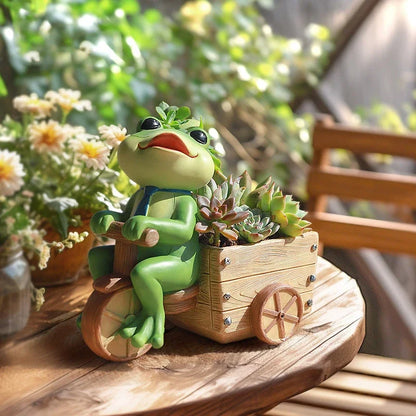 "Frog Tale" resin frog planter — Cycle Cargo styled with succulents on a wooden garden table with daisies and warm sunlight