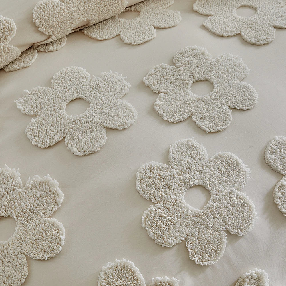 Close-up of raised tufted daisy flowers on ivory cotton duvet cover — soft fluffy texture detail in neutral ivory sand tones