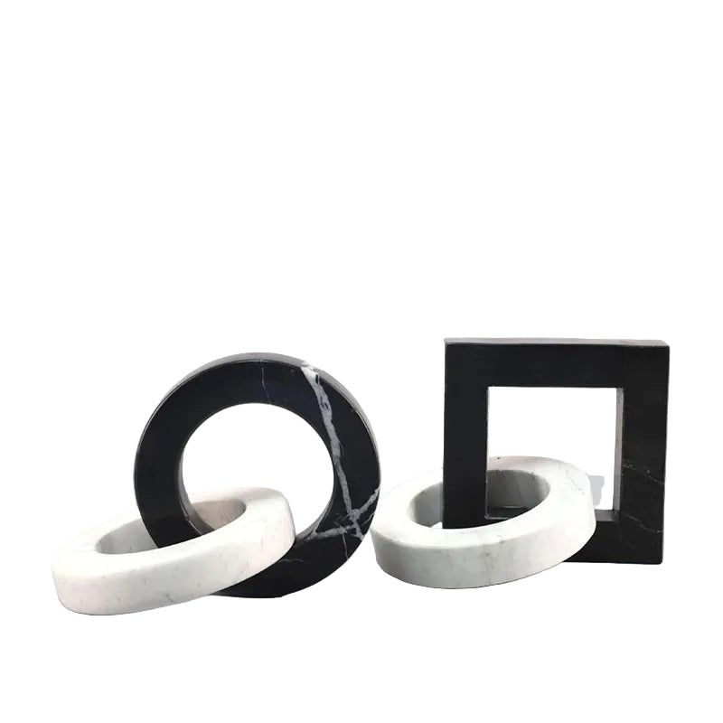 Round and square black and white interlocking marble sculptures displayed side by side on a white background.