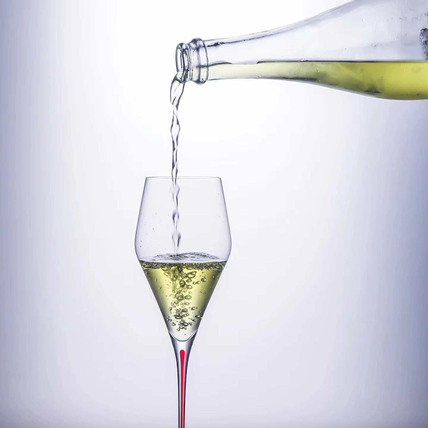  "Ink Line" geometric crystal wine glass with red stem being poured from a bottle, bold geometric design — CL House Drinkware collection