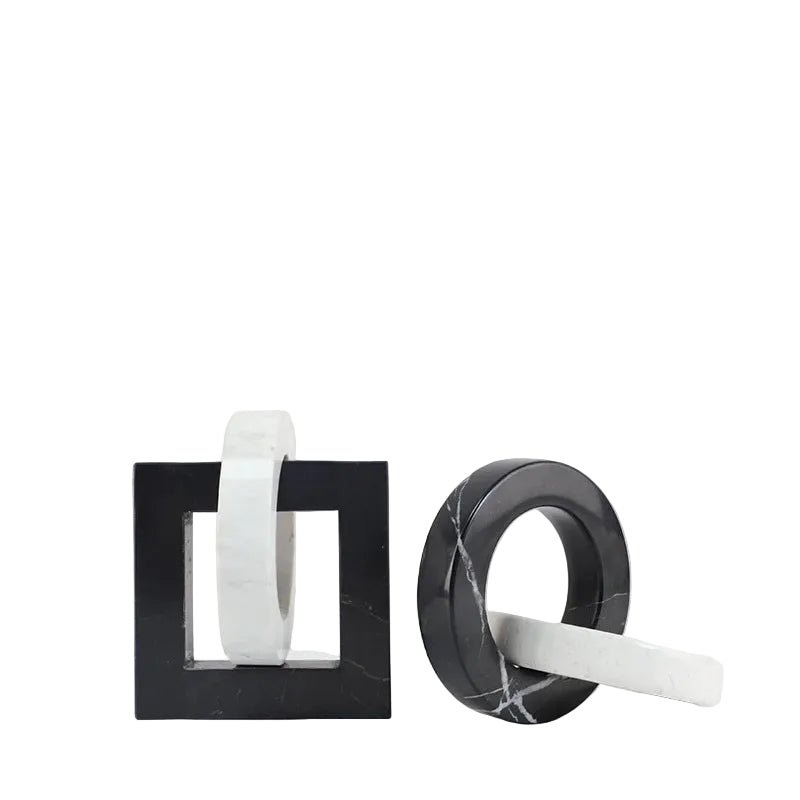 Square and round black and white interlocking marble sculptures displayed side by side on a white background.