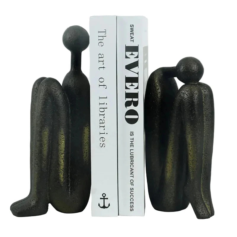 Pair of dark resin abstract human sculptures with individual dimensions shown: taller figure 9 × 5.5 × 23 cm, shorter figure 9 × 6 × 19 cm, combined pair weight 2 kg.