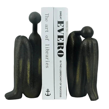 Pair of dark resin abstract human sculptures with individual dimensions shown: taller figure 9 × 5.5 × 23 cm, shorter figure 9 × 6 × 19 cm, combined pair weight 2 kg.
