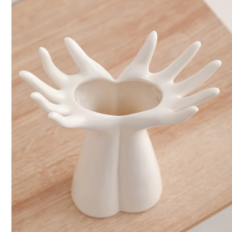 Open Hands white ceramic vase Small size top view showing open fingers and hollow centre, wooden surface
