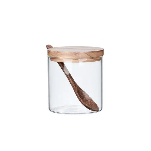 Single clear glass spice jar with acacia wood lid and wooden spoon resting inside, white background — Single Jar variant of the Acacia & Glass Spice Jar Set by CL House