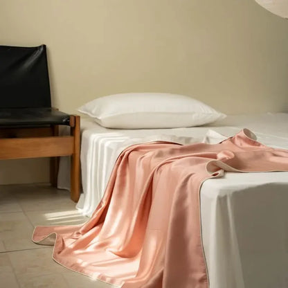  Peach Bloom 100% Tencel cooling summer blanket draped over a bed in a minimalist bedroom

