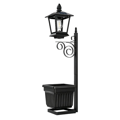 Solar garden post lantern in matte black with ornate scrollwork bracket and integrated square planter box — front view on white background