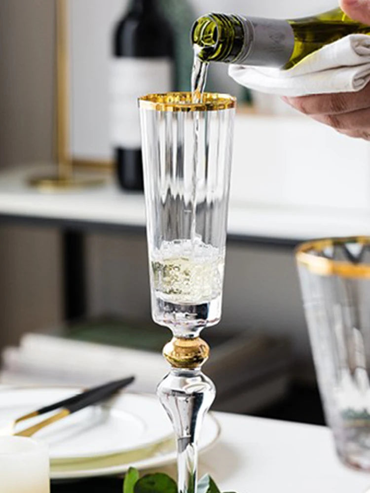  Bottle pouring champagne into a "Golden Hour" crystal champagne flute with gold filigree rim detail — CL House Drinkware collection