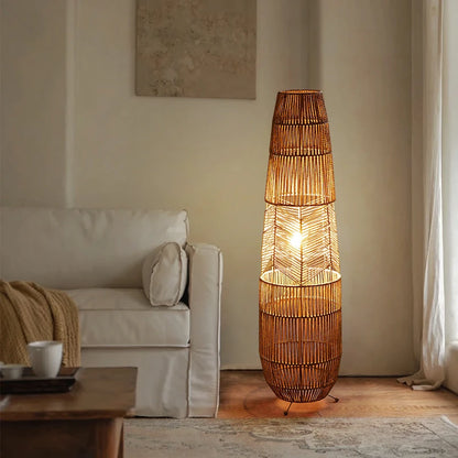  "Weave & Glow" rattan floor lamp with herringbone weave detail glowing warmly in a neutral living room corner beside a white sofa and sheer curtains