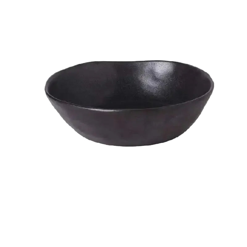 "Speckled Stone" ceramic serving bowl in matte black with organic irregular rim — front view on white background