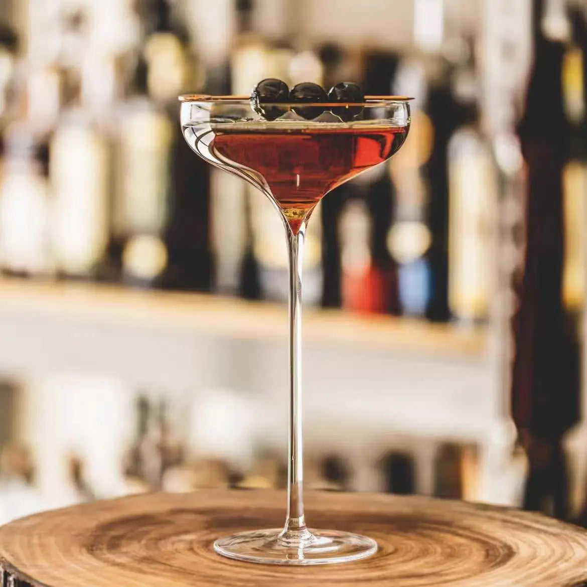 "Long Stem" coupe cocktail glass filled with a drink and fresh fruits on top, elegant wide bowl and elongated stem — CL House Drinkware collection