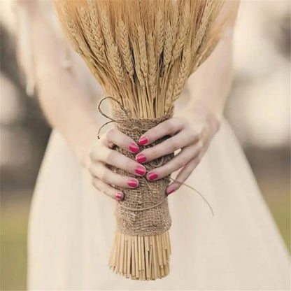  "Harvest Stem" dried wheat bundle held by hand — showing scale and natural golden texture of the dried wheat stems