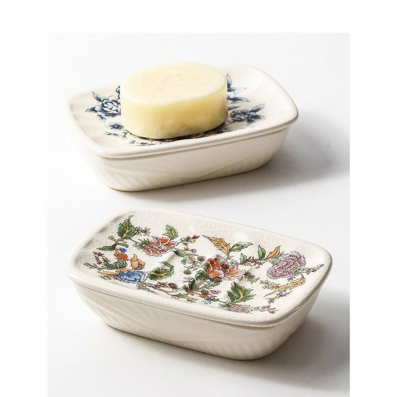 Two rectangular flat floral ceramic soap dishes — Blue Peony variant holding a natural bar of soap on top, Garden Bloom variant below, on grey background
