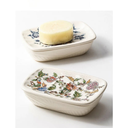 Two rectangular flat floral ceramic soap dishes — Blue Peony variant holding a natural bar of soap on top, Garden Bloom variant below, on grey background