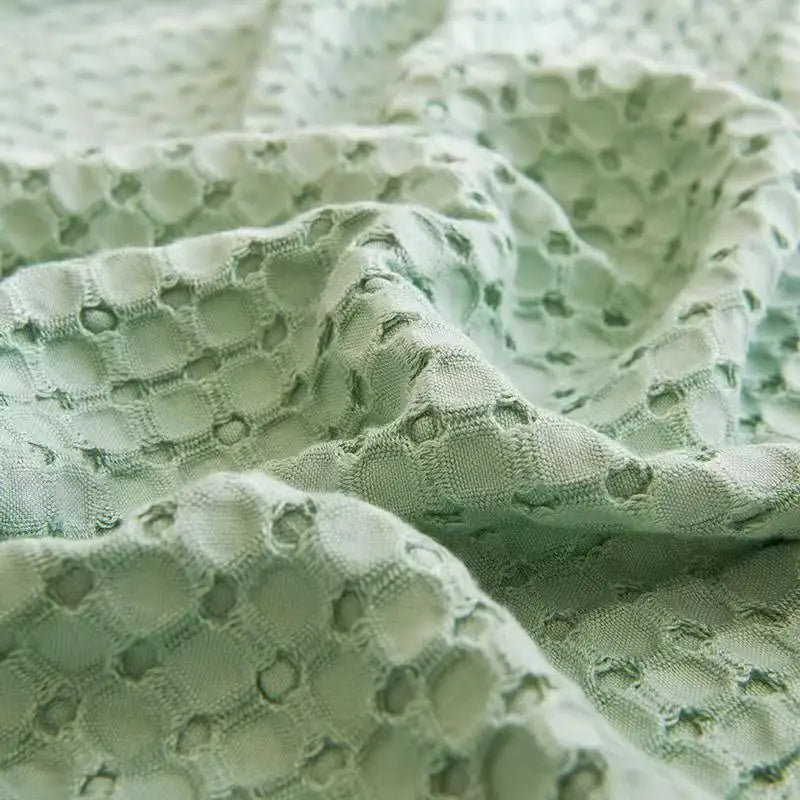 "Extreme close-up of 100% Bamboo Fibre waffle-texture cooling blanket in Sage Mist — showing the open honeycomb weave and breathable structure of the soft sage green bamboo fabric"