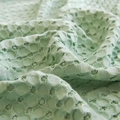 "Extreme close-up of 100% Bamboo Fibre waffle-texture cooling blanket in Sage Mist — showing the open honeycomb weave and breathable structure of the soft sage green bamboo fabric"