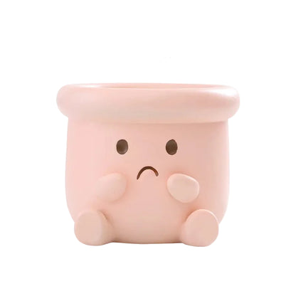 Happy Pot" sad face resin succulent planter in blush pink with worried expression, hands on cheeks and drainage hole, white background
