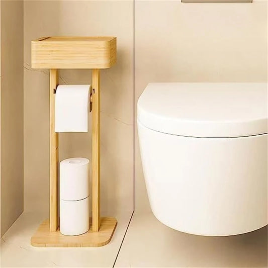 Bamboo freestanding toilet paper holder with storage box on top, placed beside a wall-hung toilet in a warm beige bathroom