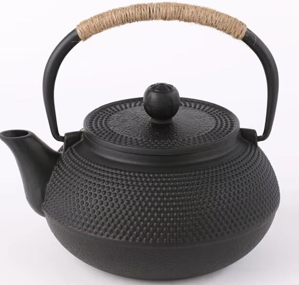 : Cast iron teapot, Iron Black finish — matte black hobnail texture, rope-wrapped handle, round black lid knob, white background — Iron Ritual by CL House