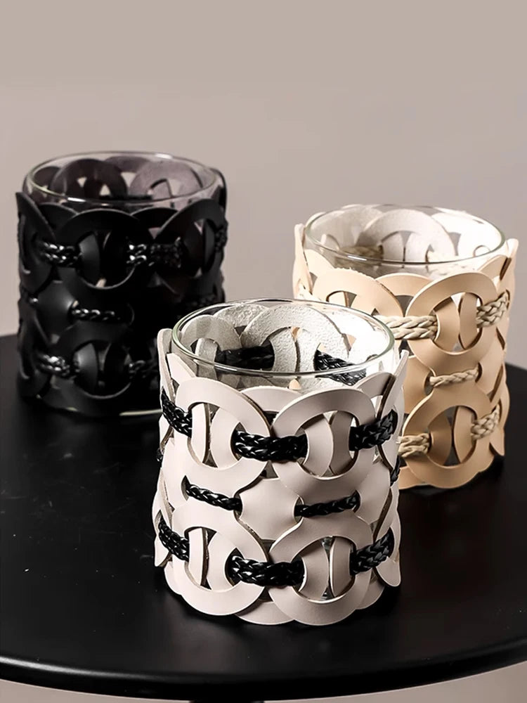  All three Chain Link woven leather bathroom organisers displayed together on dark tray — Midnight Weave, Ivory Weave, and Cognac Weave — each holding a candle, styled vignette on grey background