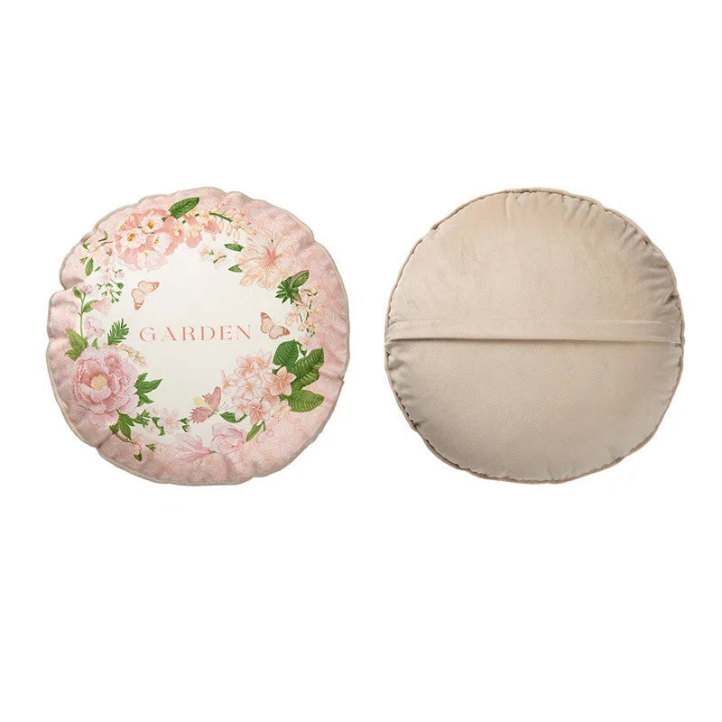  "Garden Whisper" cushion cover, Blush Garden Round design — blush pink ground with wreath of pink peonies, wild flowers and butterflies, gold "GARDEN" script at centre, scalloped edge, plain beige reverse