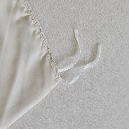 Interior corner ties detail of "Daisy Field" duvet cover to keep the duvet insert securely in place — quality overlock stitching on ivory cotton fabric