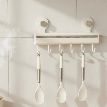 Cream adhesive wall-mounted kitchen hook rail with five sliding hooks holding white silicone spoons on white tiles, CL House & Home