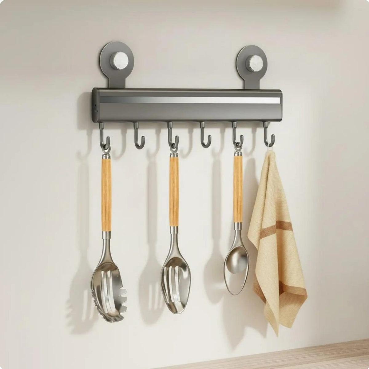 Gray adhesive wall-mounted kitchen hook rail with seven sliding hooks holding bamboo handle utensils and a linen kitchen towel, CL House & Home