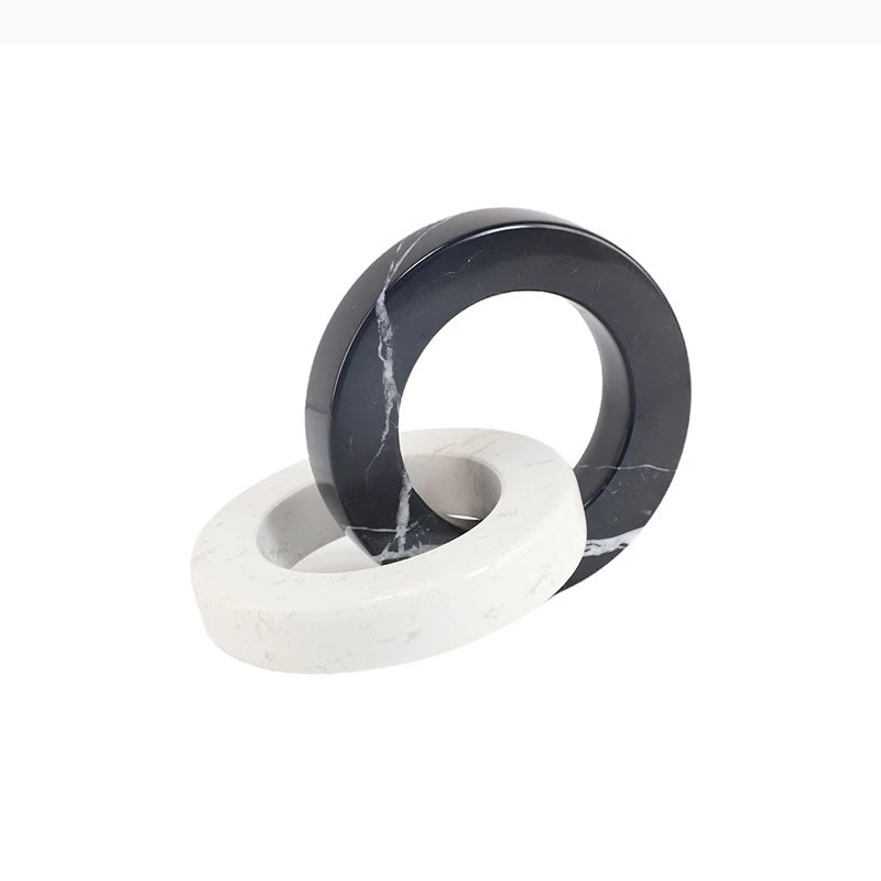 Round black and white interlocking marble sculpture displayed on a white background.
