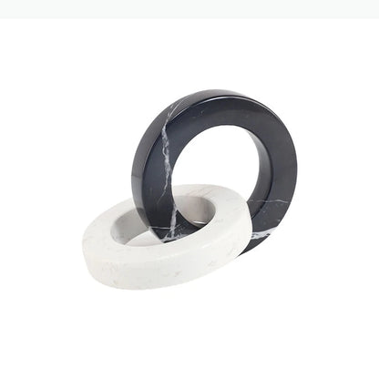 Round black and white interlocking marble sculpture displayed on a white background.
