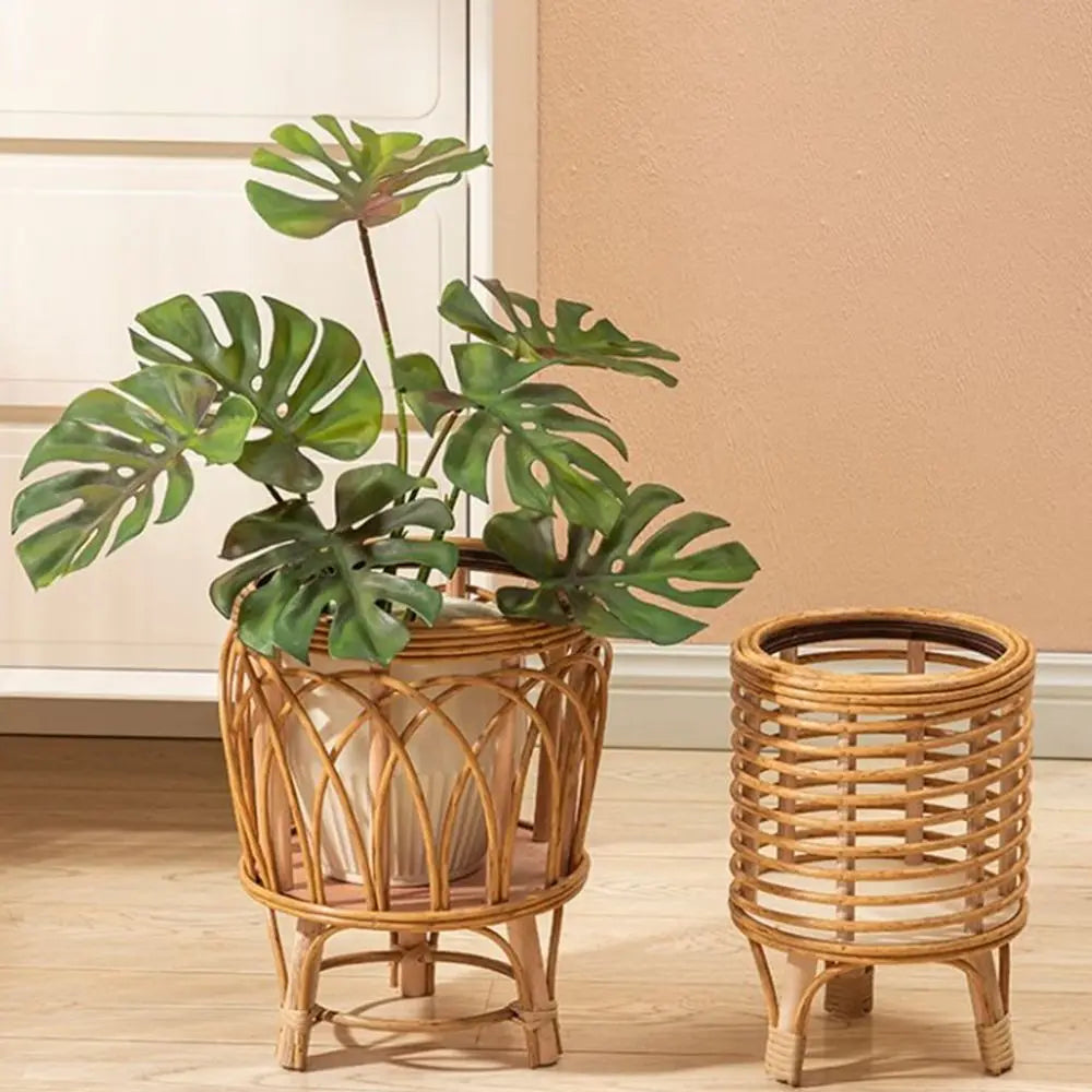  "Rattan Weave" natural rattan plant stands styled together — Arch Weave Large with monstera plant and Spiral Weave Small empty, warm honey tone finish, styled against a terracotta wall on a wooden floor