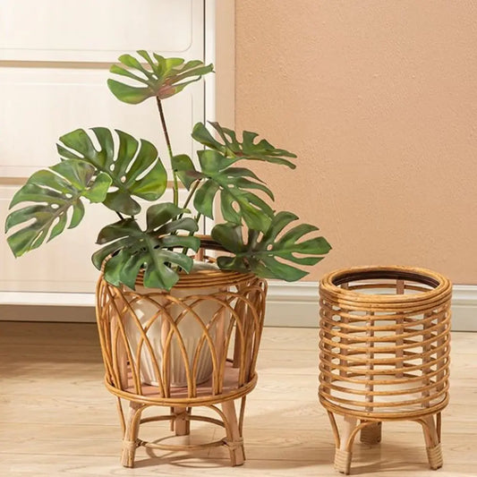 "Rattan Weave" natural rattan plant stands styled together — Arch Weave Large with monstera plant and Spiral Weave Small empty, warm honey tone finish, styled against a terracotta wall on a wooden floor