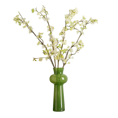 Moss Curve moss green glass vase styled with white cherry blossom branches, white background