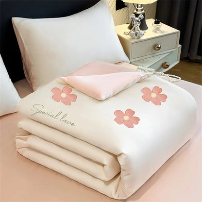 "Ice Bloom cooling summer quilt in Blossom Pink — ivory white with embroidered pink daisy motifs and 'Special Love' script detail, blush pink reverse"