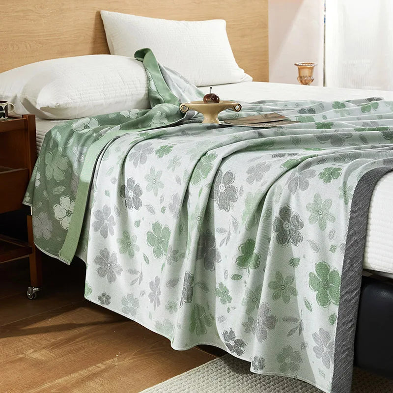 "100% Bamboo Fibre cooling blanket in Sage Blossom — white background with green and grey floral print and sage green border, lightweight summer throw styled on a bed"