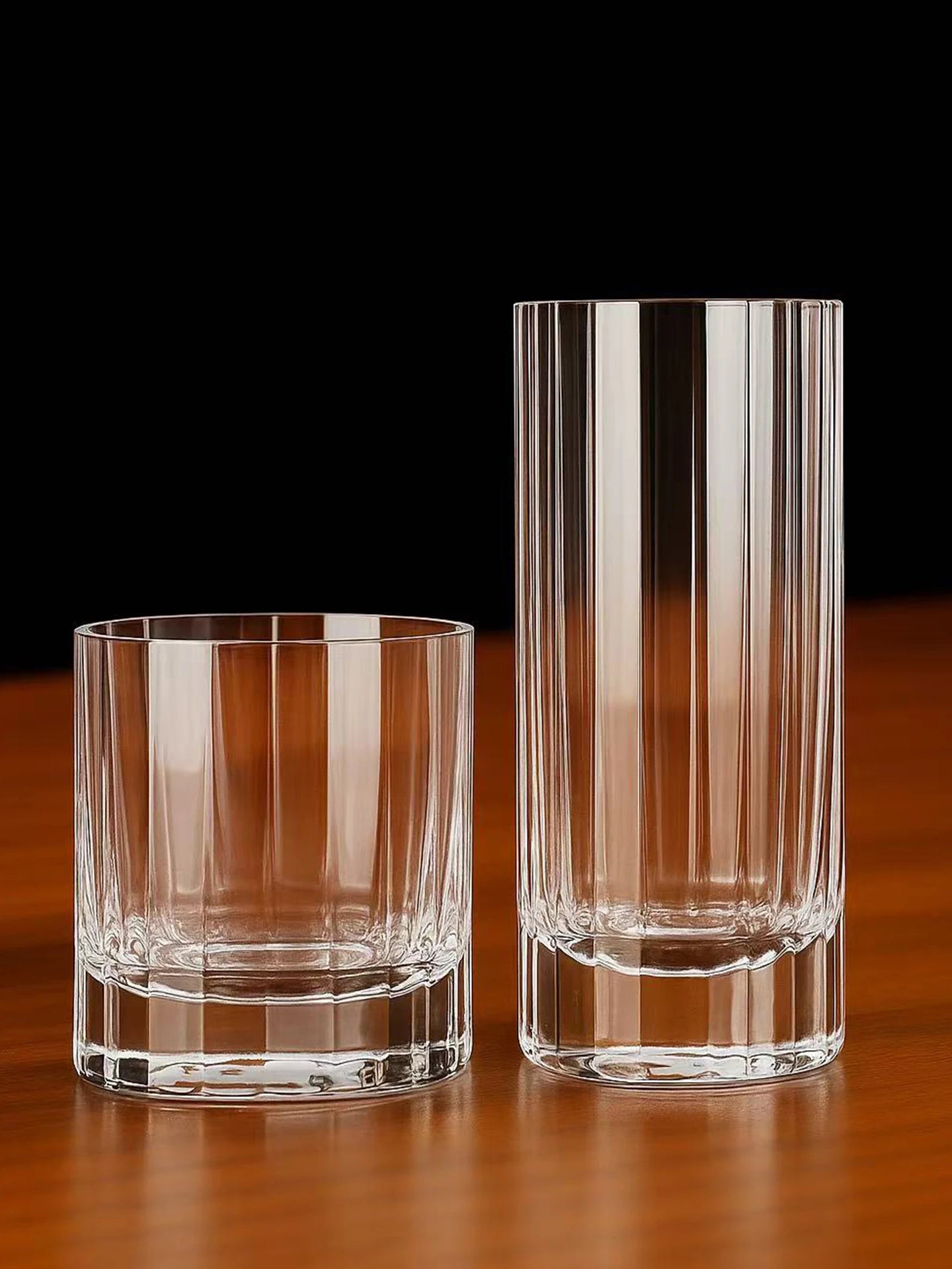 "Fluted Column" crystal rocks glass and highball glass together on a black background, elegant fluted column design — CL House Drinkware collection
