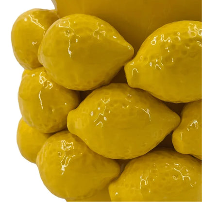Extreme close-up of glossy yellow ceramic lemon relief detailing on the Lemon Grove vase, showing the lifelike sculpted lemon texture and high-gloss sunshine yellow glaze