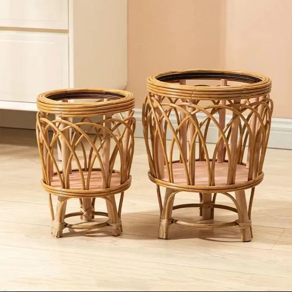 "Rattan Weave" natural rattan plant stands in Arch Weave Small and Large sizes styled as a pair, glass top inserts, four-legged base, warm honey tone finish, light wood floor and terracotta wall background