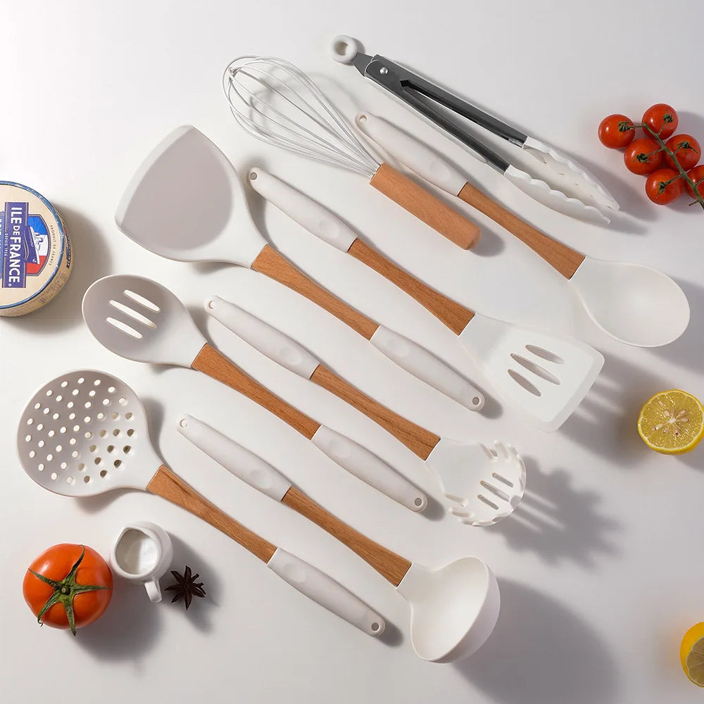 White silicone kitchen utensils set with bamboo handles laid flat on white surface styled with fresh tomatoes, cherry tomatoes, lemon and star anise, CL House & Home