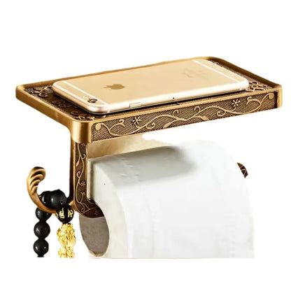 Wall-mounted antique gold toilet paper holder with engraved arabesque pattern and phone shelf, white background