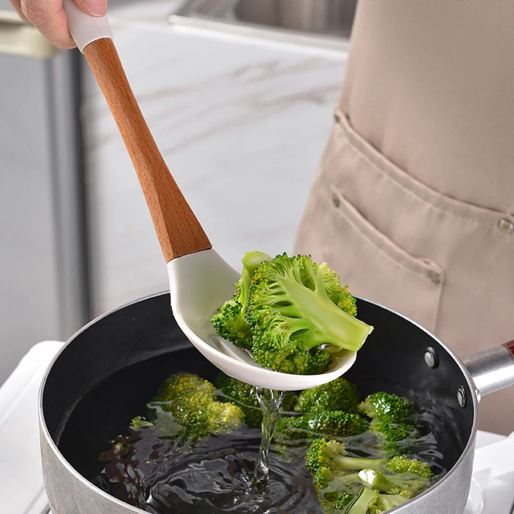 Person using white silicone ladle with bamboo handle to scoop broccoli from a pan of boiling water, CL House & Home