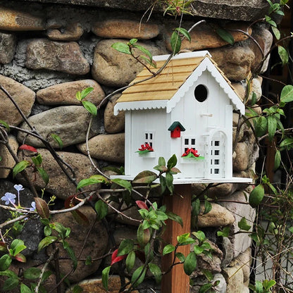 "Natural Wood House" wooden birdhouse on stake against rustic stone wall with climbing vines and wildflowers, cottage garden decoration outdoor