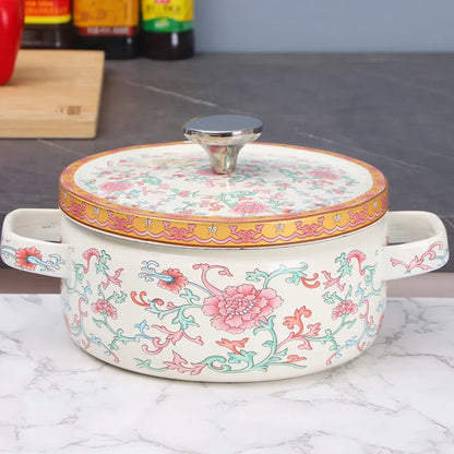  Floral enamel casserole with lid, Lotus Bloom design — styled on marble kitchen surface with wooden chopping board in background, pink lotus and vine print, gold border, steel knob — Peony Garden by CL House
