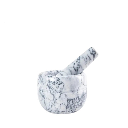 : White marble mortar and pestle with dark grey veining on white background — pestle resting inside the bowl, side angle view showing polished natural marble texture — White Marble variant of the Stone Grind Mortar & Pestle Set by CL House