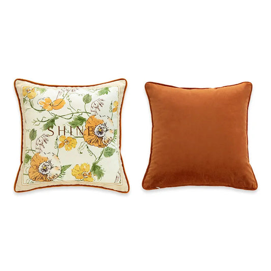  "Shine" botanical velvet cushion cover front and back view, cream ground with watercolour florals in amber, yellow and orange, typographic "SHINE" centre, plain burnt orange velvet reverse with coordinating piping — CL House Cushions collection