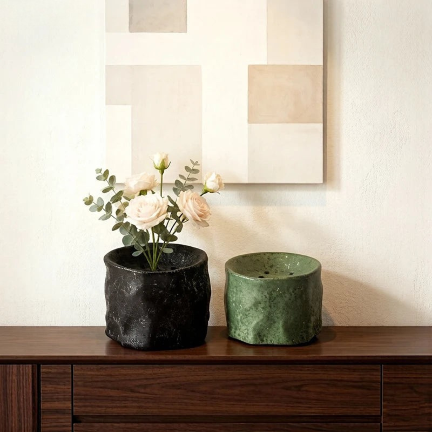 "Obsidian and Moss kenzan ceramic bowls on wooden sideboard with white rose ikebana arrangement and geometric wall art"